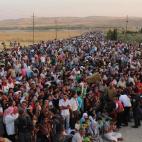 En esta fotografía tomada por funcionarios de la agencia de refugiados de las Naciones Unidas el 15 de agosto del 2013 se ve a refugiados sirios cruzando la frontera iraquí en el puesto fronterizo de Peshkabour, en Dahuk, para entrar en el sec...
