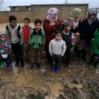 Serios, posan para el fotógrafo, después de que sus carpas, armadas sobre el barro, fueron inundadas por las lluvias, cerca del poblado Al Faour, en El Líbano, no lejos de la frontera con Siria. La  UN dice que la guerra está creando una gen...