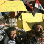 Refugiados sirios en Líbano sostienen cartulinas que dicen en árabe: "El ejército sirio libre (integrado por desertores) me protege", a la izquierda, y "Gracias al pueblo libre libanés", a la derecha, durante una manifestación frente al Com...
