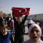 Sirios que huyeron de sus hogares debido a los combates entre el ejército sirio y los rebeldes gritan consignas mientras marchan hacia el lado turco de la frontera, durante una protesta para pedir al gobierno turco que les permita entrar a sus ...