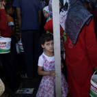 Una niña y otras personas hacen fila para comprar pan y huevos en una tienda en el puesto fronterizo de Bab Al-Salameh, cerca de la localidad siria de Azaz, el lunes 3 de septiembre de 2012. Numerosos desplazados por la violencia en Siria prete...