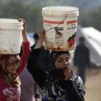 Mujeres jóvenes transportan agua en un campamento de refugiados en Atmeh, en la provincia de Idlib, norte de Siria, el martes 19 de febrero de 2013. Este campamento, que alberga a 16.000 desplazados por la guerra civil, está en control de los ...