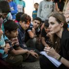 La enviada especial de la Agencia de la ONU para los Refugiados, Angelina Jolie, toma notas al conversar con refugiados sirios en un campo militar de Jordania cerca de la frontera con Siria en una fotografía del 18 de junio de 2013. Jolie prese...