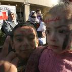 Dos niños sirios refugiados que escaparon con sus familias de la violencia en su país hacen la señal de victoria, con los rostros decorados conla bandera de la revolución siria y la frase en árabe: "Siria, la revolución", durante una manif...