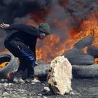 Un manifestante palestino hace una barricada durante los enfrentamientos con soldados israelíes tras una protesta contra el asentamiento israelí de Qadomem, en el pueblo Kofr Qadom, cerca de la ciudad de Nablus (Cisjordania).