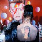 Una mujer con un tatuaje de Ziggy Stardust visita un mural de David Bowie en Brixton, al sur de Londres, el 11 de enero. La leyenda de la música murió de cáncer el 10 de enero de 2016.