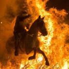 Un hombre a caballo salta una hoguera en San Bartolomé de Pinares (Ávila) durante la inauguración de las Luminarias, una fiesta tradicional en honor a San Antón, patrón de los animales, el 16 de enero.