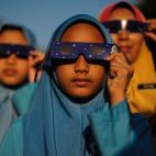 Varias estudiantes de Malasia miran el eclipse solar parcial con gafas especiales en el Planetario Nacional de Kuala Lumpur el 9 de marzo.