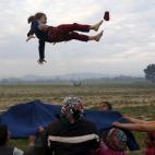 Varios niños y adultos juegan en un campamento improvisado para migrantes y refugiados entre la frontera greco-macedonia, cerca del pueblo de Idomeni, el 29 de marzo.