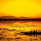 Varios pescadores descansan en su barco con la puesta de sol en el lago Dal en Srinagar (India) el 3 de mayo.