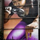 Una mujer pasa por uno de los murales del barrio Mitchell Lane el 26 de octubre en Glasgow (Escocia). Las pinturas llevan apareciendo por la ciudad desde 2008.
