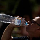 Un turista bebe agua este lunes mientras hace cola para entrar en el Palacio Real de Madrid.