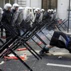 Un trabajador muestra el culo a los antidisturbios desplegados en los alrededores del Parlamentos europeo en Bruselas durante las manifestaciones de trabajadores y sindicalistas de la UE para pedir más protección laboral.