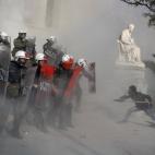 Un antisistema trata de atacar a los antidisturbios durante una protesta en Atenas contra las prisiones de máxima seguridad griegas.