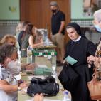 Una monja espera junto a la urna pera jercer su derecho al voto en el colegio Sagrado Corazón de Málaga.