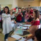 La candidata de Vox a la presidencia de la Junta de Andalucía, Macarena Olona, muestra el sobre con su papeleta momentos antes de introducirlo a la urna y ejercer su derecho al voto en el Hogar del Pensionista de Salobreña (Granada).
