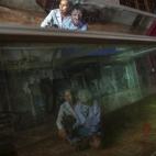 Dang Thi Quang y su hijo Nguyen Van Binh se ven reflejados en el acuario de su casa en  Quang Binh. El padre de familia fue otro soldado afectado por el agente. 
