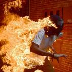 Jos&eacute; V&iacute;ctor Salazar es un manifestante que corre entre las llamas durante las protestas contra el presidente Nicol&aacute;s Maduro, en Caracas, Venezuela.