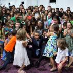 Obama gets help from students after posing for a photo at Dillingham Middle School in Dillingham, Alaska, on Sept. 2, 2015.