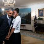First lady Michelle Obama snuggles against President Barack Obama before a videotaping for the 2015 World Expo in the Diplomatic Reception Room of the White House on March 27, 2015.