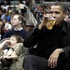 Obama, sitting next to 5-year-old Nick Aiello (L), sips his beverage while attending the Washington Wizards NBA basketball game against the Chicago Bulls in Washington, February 27, 2009.