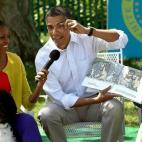 Obama acts out a part of the story while reading from the book Where The Wild Things Are with first lady Michelle Obama (L) and his daughter Sasha (R) during the White House Easter Egg Roll on the South Lawn of the White House on April 9, 2...
