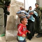 Un niño llora al lado de mujeres palestinas que discuten con soldados israelíes mientras tratan de cruzar desde Abu Dis a Jerusalén este el 26 de marzo de 2006. La polémica barrera que impide el acceso directo desde Cisjordania a Israel es l...
