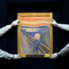 Empleados de Sotheby's posan junto a la versión en colores pastel sobre pizarra de El grito del artista noruego Edvard Munch durante una subasta en el centro de Londres el 12 de abril de 2012. El 2 de mayo de ese año, el cuadro se vendió por ...