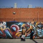 Un hombre pasa junto a un mural en el centro de Los Ángeles, California.
