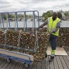 Un trabajador retira los 'candados del amor' del Puente de las Artes en París.