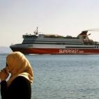 Una inmigrante afgana espera sus documentos temporales, que le permitirán comprar tickets para un ferry hacia Atenas, a la salida de una comisaria cerca del puerto de la isla griega de Kos.