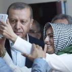 Una joven se saca un selfie con Erdogan en su colegio electoral.