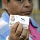 Una mujer muestra su número en la línea de espera para comprar en un mercado en San Cristóbal, Táchira.
