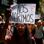 A demonstrator holds a sign reading 'We do die', during a protest against the government of President Nicolas Maduro, called by opposition leader and self-proclaimed 'acting president' Juan Guaido, outside the 'Dr. JM de los Rios' Children's Hos...