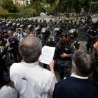 Venezuela's Central University (UCV) professor Juan Carlos Apitz (C) reads an amnesty proposal of opposition leader and self-proclaimed 'acting president' Juan Guaido, to members of the Bolivarian National Police (PNB), outside the UCV in Caraca...