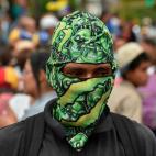 A masked opposition demonstrators takes part in a protest against the government of President Nicolas Maduro, called by opposition leader and self-proclaimed 'acting president' Juan Guaido, at Altamira square in Caracas on January 30, 2019. - Ve...