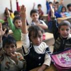 Niños atienden en clase en Siria.