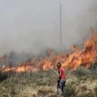 Un voluntario trata de sofocar un incendio en el suburbio de Ilioupoli en Atenas (Grecia).