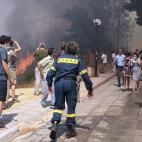 Bomberos tratan de sofocar un incendioen el suburbio de Karea en Atenas (Grecia).