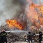 Bomberos tratan de sofocar un incendio en el suburbio de Karea en Atenas (Grecia).