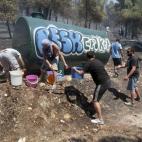 Voluntarios tratan de sofocar un incendio en el suburbio de Karea en Atenas (Grecia).