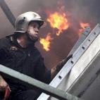 Un bombrero intenta extinguir las llamas en el suburbio de Karea en Atenas (Grecia).