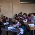 Un chico de la oposición, Abu Yassin, de 21, da clase a unos chicos en un barrio de la ciudad de Alepo (Siria) en Septiembre de 2013. 