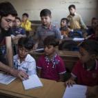 Abu Yassin, combatiente de la oposición, enseña a los niños en la ciudad de Alepo (Siria). 