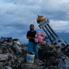 Una mujer sujeta su conejo de peluche despu&eacute;s de encontrarlo entre las ruinas de su casa destru&iacute;da, donde ha perdido a sus tres hijos, en Indonesia.