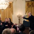 Un miembro del personal de la Casa Blanca intenta cogerle el micr&oacute;fono al periodista de la CNN Jim Acosta, que cuestionaba al presidente Trump durante una rueda de prensa.
