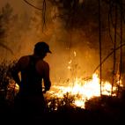 Un hombre trata de extinguir el fuego en Junqueira, en Ferreira do Zezere.