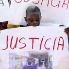 Un niño sostiene un cartel en el que pide "justicia" tras la muerte del senegalés.