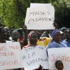 Varios manifestantes sostienen pancartas en las que piden justicia y llaman asesinos a los Mossos tras la muerte de un compatriota senegalés.