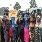 Grupo de mulheres espera na chuva para se registrar e receber status de refugiadas no ponto de coleta Kuluba. Ponto de coleta Kuluba, 1º de novembro de 2016.